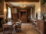 une grande pièce avec une cheminée et une grande tapisserie accrochée au mur