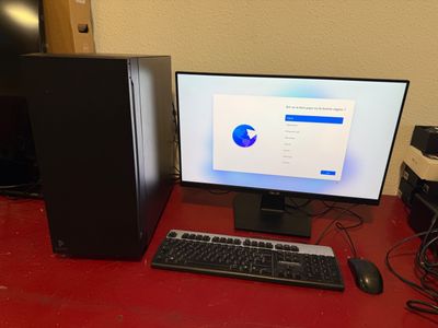 a desktop computer sitting on a red desk with a keyboard and mouse