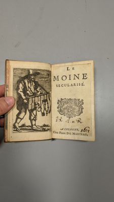 quelqu'un tient un livre sur lequel figure l'image d'un homme à cheval