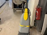 un aspirateur posé sur le sol de la pièce
