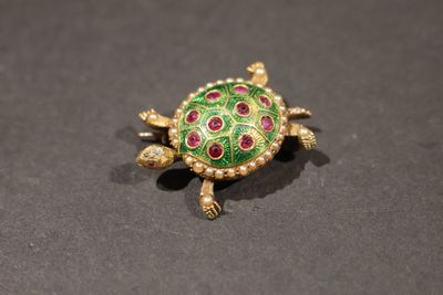 un gros plan d'une broche en forme de tortue posée sur une table