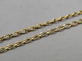 a pair of gold chains on a gray surface