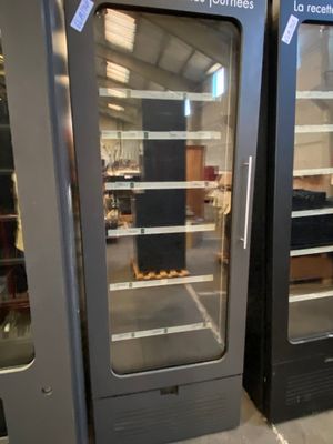 two refrigerators that are sitting side by side in a warehouse