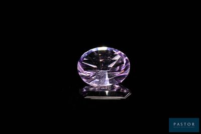 a purple diamond on a black surface with a black background