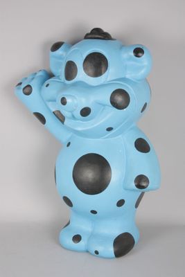 une statue d'ours à pois bleus et noirs posée sur une surface blanche