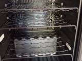 an open oven with many racks of food inside of it