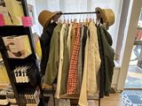 un présentoir de vêtements et de chapeaux sur un portemanteau dans un magasin