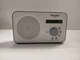 a radio that is sitting on a table next to a cup