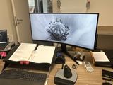 a desk with a computer, keyboard, mouse, and other items on it