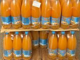 many bottles of orange juice sitting on a pallet