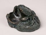 a statue of a frog that is sitting on a rock