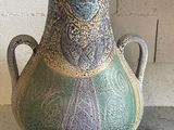 a vase that is sitting on a table next to a brick wall