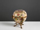 une petite boîte décorative posée sur un socle, sur une table