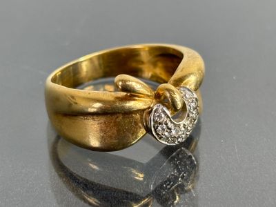 a gold ring with a diamond in it on a table