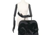 the mannequin is holding a black handbag on a mannequin stand
