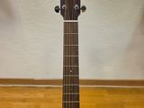 an acoustic guitar sitting on a hard wood floor in a room