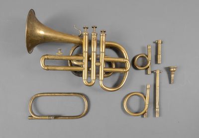an image of a brass trumpet and other musical instruments on a gray surface