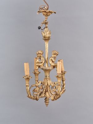 une image représentant un lustre en or surmonté d'un oiseau