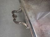 a silver purse with a handle on the floor