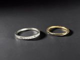 two gold and silver rings on a black surface
