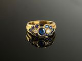 a close up of a gold ring with blue sapphires and diamonds