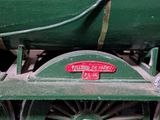 a close up of a green train engine with a red sign on it