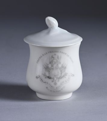 a small white cup with a lid on a table
