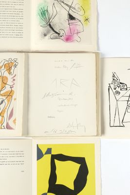 quatre livres ouverts, ornés de dessins, posés sur une surface blanche