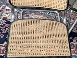 three wicker chairs sitting on top of a rug on top of a carpet