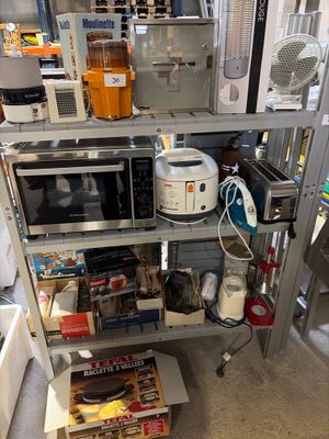une cuisine équipée d'un micro-ondes, d'un grille-pain, d'un grille-pain, d'un grille-pain et d'autres ustensiles rangés sur les étagères