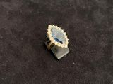 an image of a ring with a blue stone on top of a black surface
