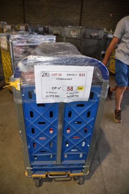 un chariot sur lequel est accrochée une pancarte, garé dans un entrepôt