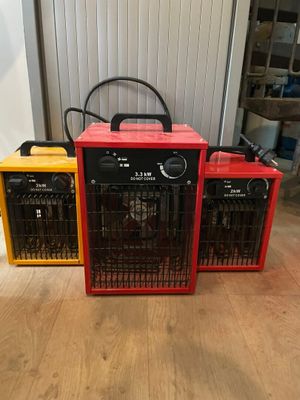 trois radiateurs électriques rouges et jaunes posés sur un parquet en bois massif
