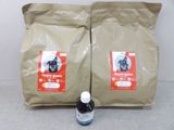 deux sacs de croquettes pour chien posés à côté d'une bouteille de liquide
