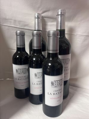 quatre bouteilles de vin sont alignées sur une nappe blanche