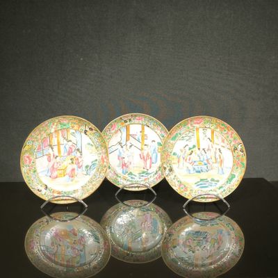 trois assiettes chinoises ornées de motifs, posées sur une table