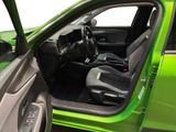 the interior of a green car with the door open and the driver ' s seat up
