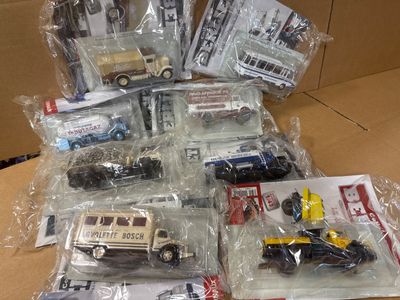 beaucoup de petits véhicules jouets dans des sacs, posés sur une table