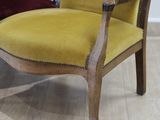 a yellow chair sitting on a wooden floor next to a red chair