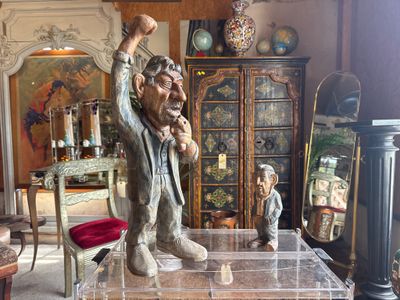 a statue of a man sitting on a table in a living room