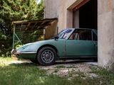 a green car that is parked in front of a building