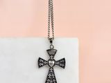 une croix noire et blanche surmontée d'une couronne, posée sur un bloc de marbre