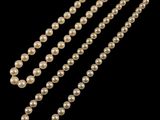 a close up of a pearl necklace on a black background