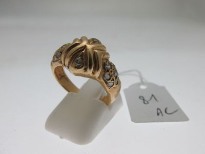 an image of a gold ring with black diamonds on a white surface