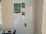 a white refrigerator in a small room with a window