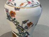 a white vase with a floral design on it
