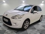 la petite voiture blanche est garée sur un sol en damier