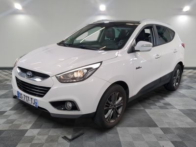 la voiture blanche est garée sur un sol en damier dans le garage