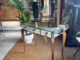 a glass table with a mirror on it and a potted plant on the table