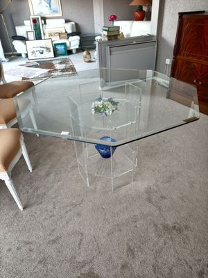 une table en verre sur laquelle trône un vase bleu, au milieu d'un salon